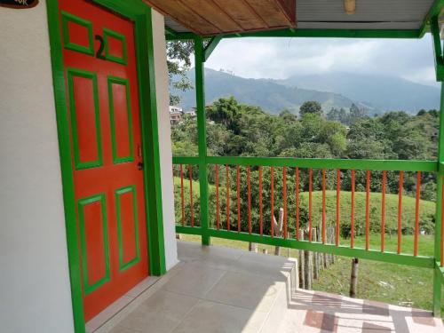 eine rote Tür auf einem Balkon mit Aussicht in der Unterkunft Hostal Bamboo in Salento