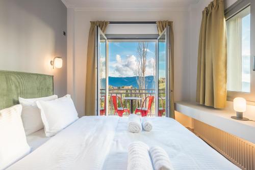 a bedroom with a bed with a view of a balcony at Snowglory Boutique Hotel in Arachova