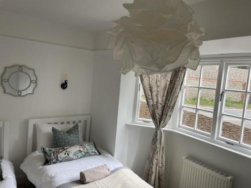 1 dormitorio con cama y ventana en Cottage Number 5 in Southwold - Charming cottage gardens, en Southwold