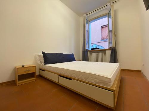 een klein bed in een kamer met een raam bij Les Tres Chic in Cesena