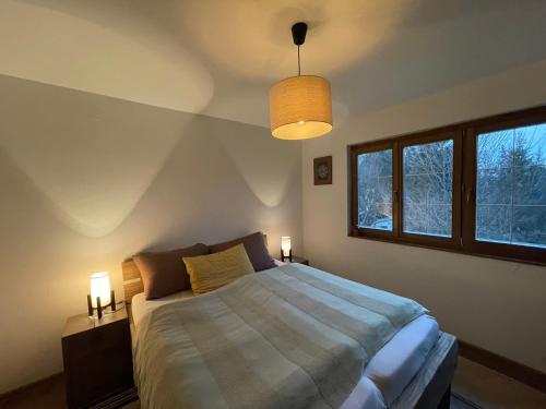 a bedroom with a bed with two lamps and a window at Vikendica Paša in Pale