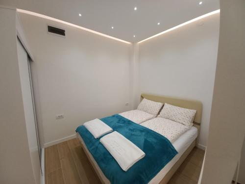 a small bedroom with a bed in a white room at Studio Apartman Bambi in Pale