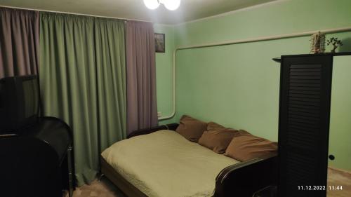 ミルゴロドにある3к квартира 1 этажのベッドルーム(ベッド1台、テレビ、カーテン付)