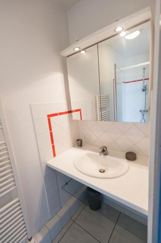 une salle de bain blanche avec un lavabo et un miroir dans l'établissement Le Neptune Apt 85m2 3ch Appart Hotel Poitiers, à Poitiers