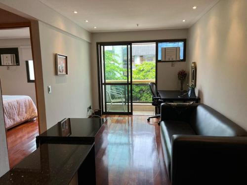 sala de estar con sofá y ventana en APART HOTEL LUXO IPANEMA, en Río de Janeiro