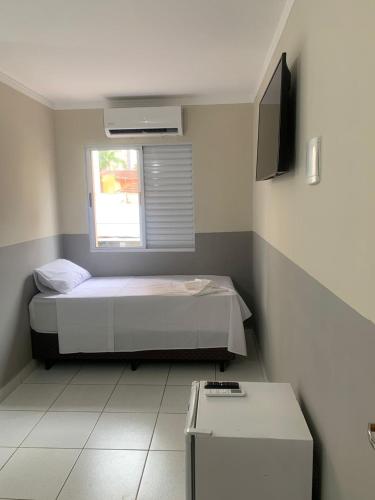 a small bedroom with a bed and a window at Hotel Barão Ribeirão in Ribeirão Preto