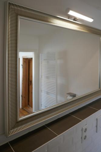 ein großer Spiegel an einer Wand im Badezimmer in der Unterkunft Roter Hirsch in Oderberg