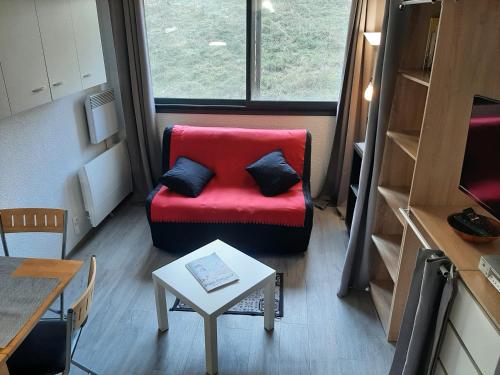 uma sala de estar com um sofá vermelho e uma mesa em Les Pioupious de Club Engaly 2 pour 4 personnes em Aragnouet