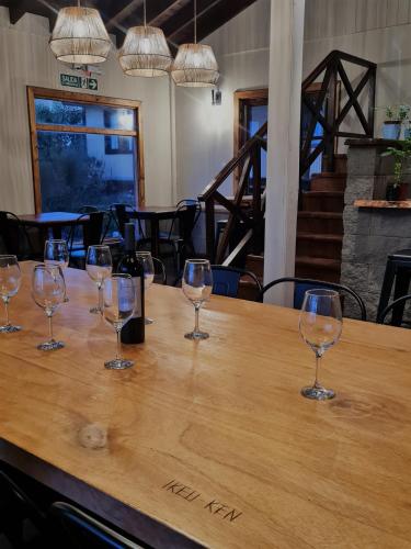 eine Gruppe Weingläser, die auf einem Tisch sitzen in der Unterkunft Cabañas y Hostel I Keu Ken in El Calafate