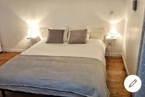ein Schlafzimmer mit einem großen weißen Bett mit zwei Lampen in der Unterkunft L'escale Cocooning Appartement T2 Centre 3 Étoiles in Bagnères-de-Bigorre