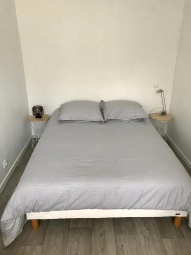 Ce lit se trouve dans un dortoir doté de 2 tables de chevet. dans l'établissement Maisonnette de charme au calme près des bords de Marnes, à Saint-Maur-des-Fossés