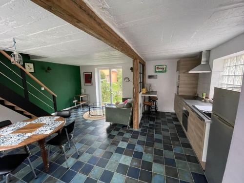 une cuisine avec une table et une salle à manger dans l'établissement Charmante petite maison, à Dinsheim
