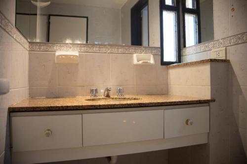 ein Badezimmer mit Waschbecken und Spiegel in der Unterkunft Hotel La Colina del Sol in Villa Carlos Paz