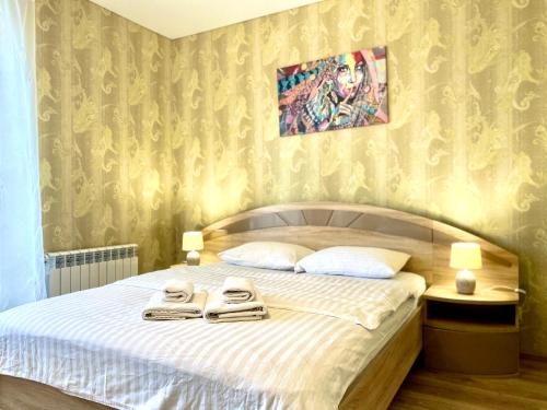 - une chambre avec un lit et 2 serviettes dans l'établissement ApartPoltava НОВИЙ будинок, в самому ЦЕНТРІ 2-ОКРЕМІ кімнати, ПАНОРАМНИЙ БАЛКОН, à Poltava