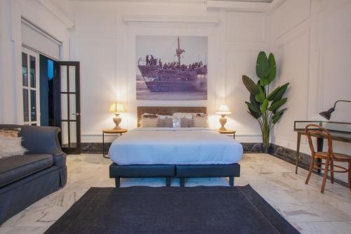 ein Schlafzimmer mit einem großen Bett und einer Couch in der Unterkunft AmazINN Places Casco Viejo Pool and Rooftop VI in Panama-Stadt