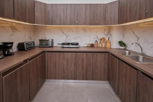 eine Küche mit Holzschränken und einer Spüle in der Unterkunft AmazINN Places Casco Viejo Pool and Rooftop VI in Panama-Stadt