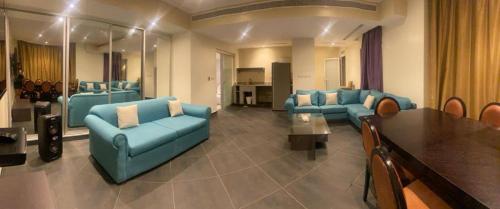 uma grande sala de estar com sofás azuis e uma mesa em Bana Bana Resort em Durat Alarous