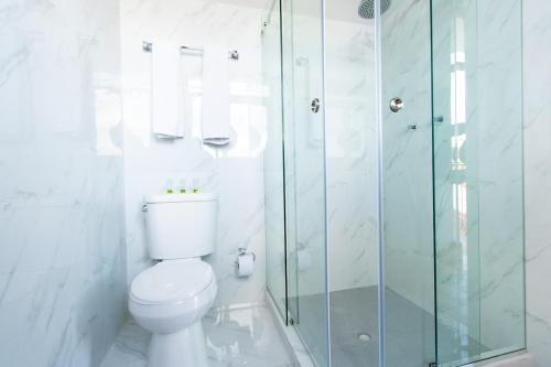 een badkamer met een toilet en een glazen douche bij AmazINN Places Casco Viejo Pool and Rooftop XI in Panama-Stad