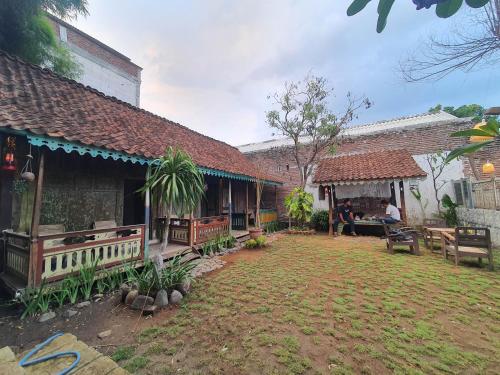 a courtyard of a building with people sitting on a bench at Happy House BnB Bromo backpacker in Probolinggo