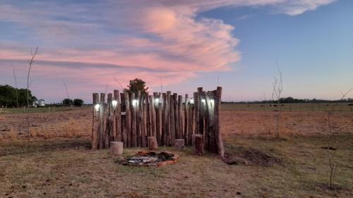 a wooden fence with lights on it in a field at Cabañas El Encuentro Lobos in Salvador María
