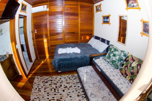 a small room with a bed and a couch at Espaço Vintage in Piçarras