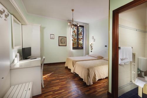a bedroom with two beds and a television in it at Hotel Savona in Montecatini Terme