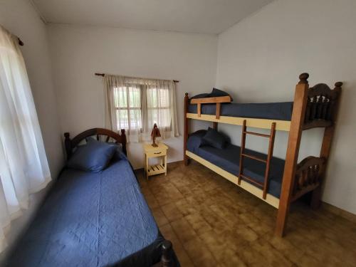 a bedroom with two bunk beds and a window at Otto's Haus in Villa General Belgrano