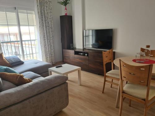 sala de estar con sofá, TV y mesa en Apartamento en Nerja, en Nerja