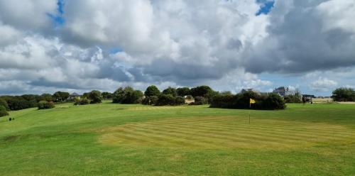 a view of a golf course with a green field at Wheal Prosper- Beautifully Fitted Wooden Lodge Helston Cornwall in Helston