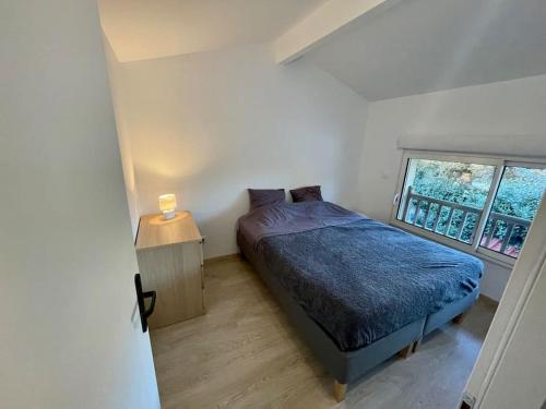 a small bedroom with a bed and a window at Au calme, maison T3 neuf avec Jardin à Cassy in Lanton