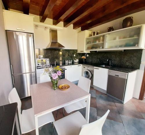 a kitchen with a table with a vase of flowers on it at NAVASA in Navasa