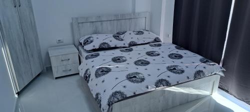 ein Schlafzimmer mit einem Bett mit einer schwarz-weißen Bettdecke in der Unterkunft Apartment Alex in Sarandë