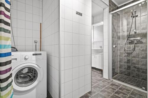 a bathroom with a washing machine and a shower at Skjomtind - Modern apartment with free parking in Narvik