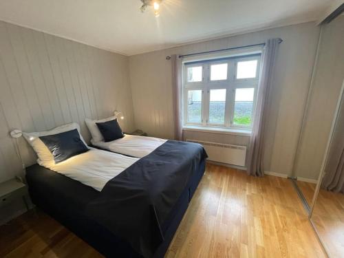 a bedroom with a large bed with a window at Skjomtind - Modern apartment with free parking in Narvik