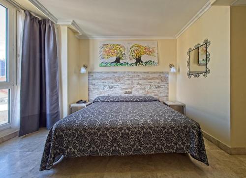 a bedroom with a bed and a painting on the wall at Caballero Errante in Madrid