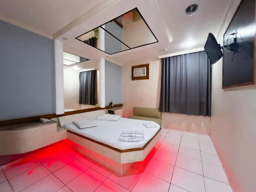 a room with a bed with red lights in it at Status Motel in Niterói