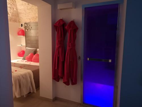 um quarto com dois vestidos vermelhos pendurados numa parede em Suite Mazzini con piscina em Ostuni