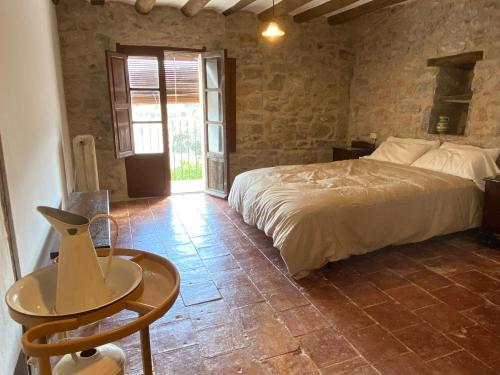 1 dormitorio con 1 cama y 1 mesa en una habitación en Masía La Perera, en Morella