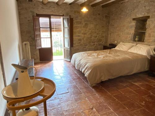 a bedroom with a bed and a table in a room at Masía La Perera in Morella