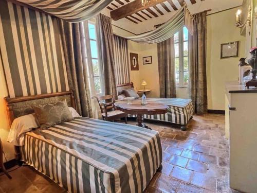 1 dormitorio con 1 cama, mesa y sillas en Chez Lydia - Osez la vie de chateau ! Pont du Gard, Uzès en Remoulins