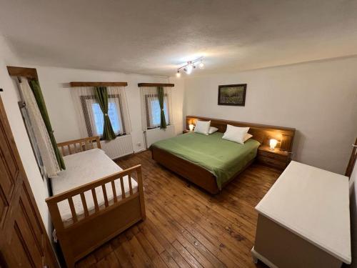1 dormitorio con 1 cama verde y 2 ventanas en Haus Ingrid Cisnadioara, en Cisnădioara