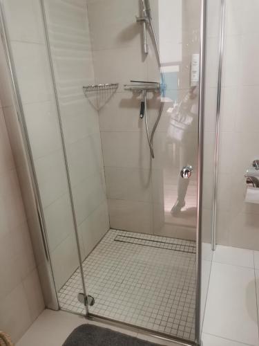 um chuveiro com uma porta de vidro na casa de banho em Apartament przy plaży em Międzyzdroje