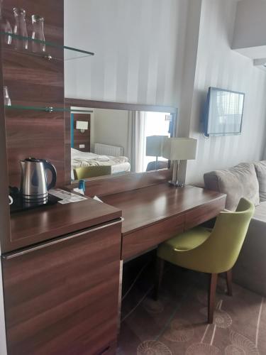 uma cozinha com uma secretária de madeira e uma cadeira amarela em Apartament przy plaży em Międzyzdroje
