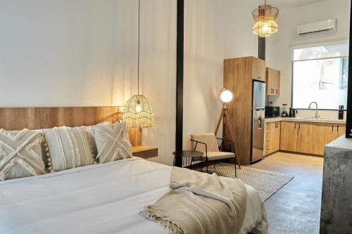 een slaapkamer met een groot wit bed en een keuken bij AmazINN Places Rooftop and Design Pool II in Panama-Stad