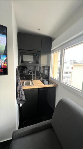 a small kitchen with a sink and a counter top at Appartement F2 meublé - tout équipé - Tv netflix - 4 personnes in Lisieux