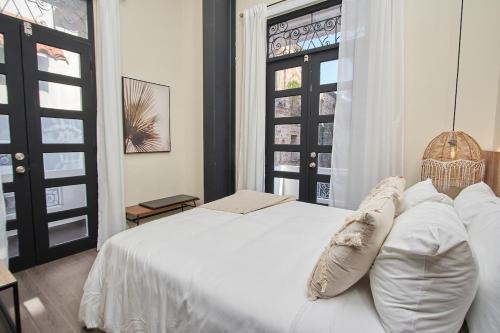 une chambre avec un lit blanc et une fenêtre dans l'établissement AmazINN Places Rooftop and Design Pool I, à Panama City