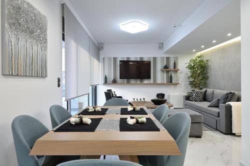 The Lop Athens Holidays Luxury Suites في أثينا: غرفة طعام مع طاولة وكراسي