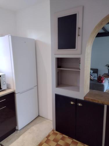 a kitchen with a white refrigerator and a tv at La Coste Blanque in Montaut