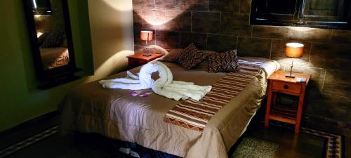 a bedroom with a bed with towels on it at Hotel Sante in Tinogasta
