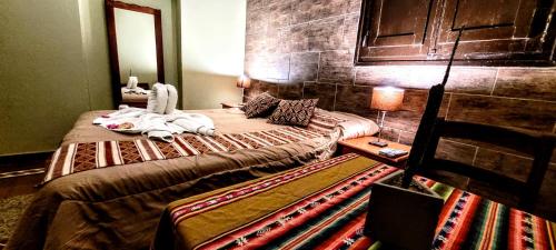 a bedroom with two beds and a table with a mirror at Hotel Sante in Tinogasta
